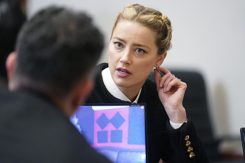Actor Amber Heard speaks with a member of her legal team in the courtroom at the Fairfax County Circuit Courthouse in Fairfax, Va., Thursday, May 19, 2022. Actor Johnny Depp sued his ex-wife Amber Heard for libel in Fairfax County Circuit Court after she wrote an op-ed piece in The Washington Post in 2018 referring to herself as a "public figure representing domestic abuse." (Shawn Thew/Pool Photo via AP)