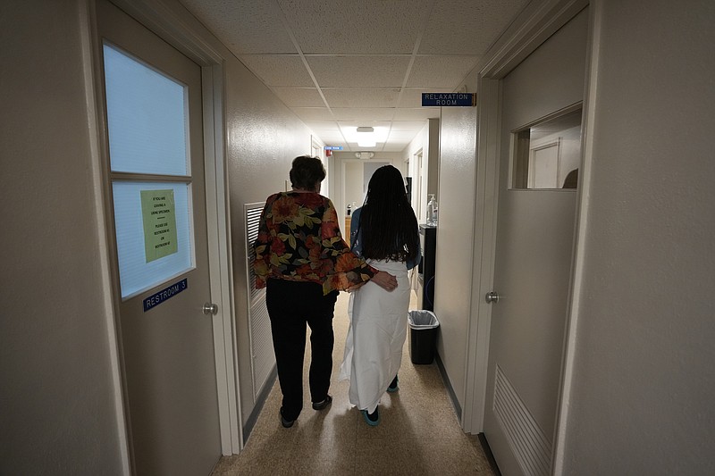 A 33-year-old mother of three from central Texas is escorted down the hall by clinic administrator Kathaleen Pittman prior to getting an abortion, Oct. 9, 2021, at Hope Medical Group for Women in Shreveport, La. Reproductive rights advocates are planning to open new abortion clinics or expand the capacity of existing ones in states without restrictive abortion laws. (AP Photo/Rebecca Blackwell, File)