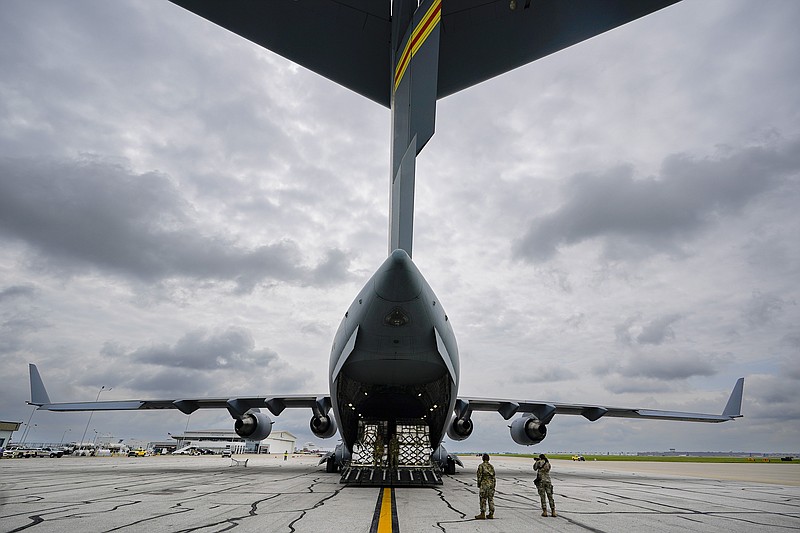 The crew of an Air Force C-17 begins to unload a plane load of baby formula at the Indianapolis International Airport in Indianapolis, Sunday, May 22, 2022. The 132 pallets of Nestlé Health Science Alfamino Infant and Alfamino Junior formula arrived from Ramstein Air Base in Germany (AP Photo/Michael Conroy)