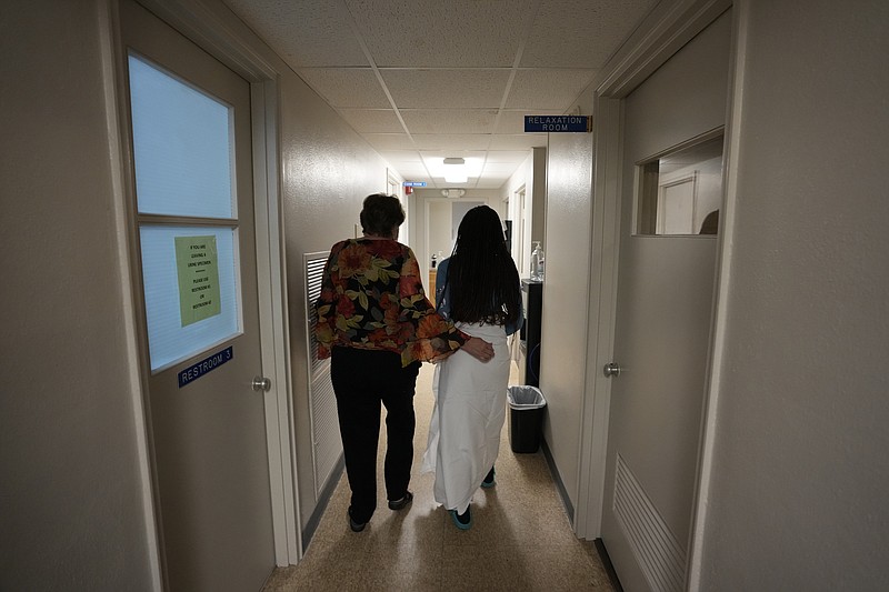 FILE - A 33-year-old mother of three from central Texas is escorted down the hall by clinic administrator Kathaleen Pittman prior to getting an abortion, Oct. 9, 2021, at Hope Medical Group for Women in Shreveport, La. Reproductive rights advocates are planning to open new abortion clinics or expand the capacity of existing ones in states without restrictive abortion laws. (AP Photo/Rebecca Blackwell, File)