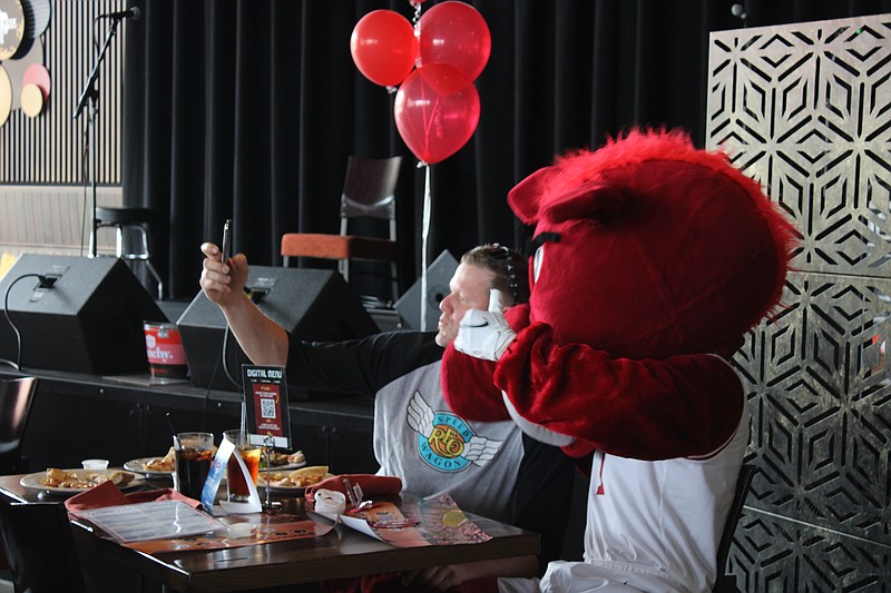 Big Red poses for a selfie with a fan during the ONE Razorback Roadshow at Mulekick at MAD on Wednesday, May 18. (Caitlan Butler/News-Times)