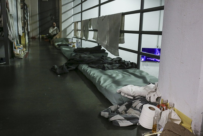 Bed mats are set up along an overflow bunking area near a walkway railing, Monday, January 10, 2022 at the Washington County Detention Center in Fayetteville. (NWA Democrat-Gazette/Charlie Kaijo)