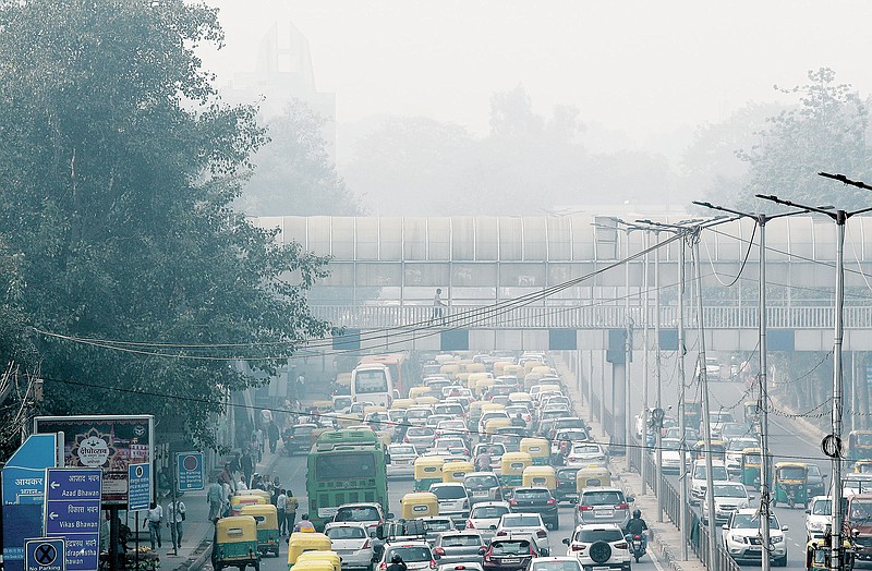 FILE - A pedestrian walks on a bridge above vehicle traffic in New Delhi, India, Tuesday, Nov. 12, 2019, as the city is enveloped under thick smog. The air quality index exceeded 400, about eight times the recommended maximum. A study released on Tuesday, May 17, 2022, blames pollution of all types for 9 million deaths a year globally, with the death toll attributed to dirty air from cars, trucks and industry rising 55% since 2000. (AP Photo/Manish Swarup, File)