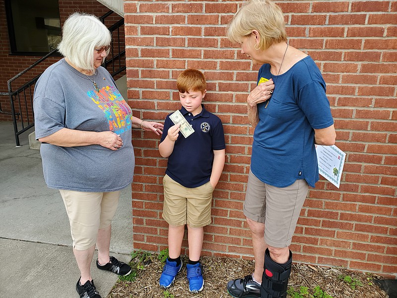 St. Peter Catholic School student Brody Bax, at center, receives a $20 award for winning a state poetry contest sponsored locally by the Bittersweet Garden Club. Bax's teacher, Jane Schnieder, at left, looks on as does the club's Sharon Burnett, at right. (Photo by Jeff Haldiman/News Tribune)