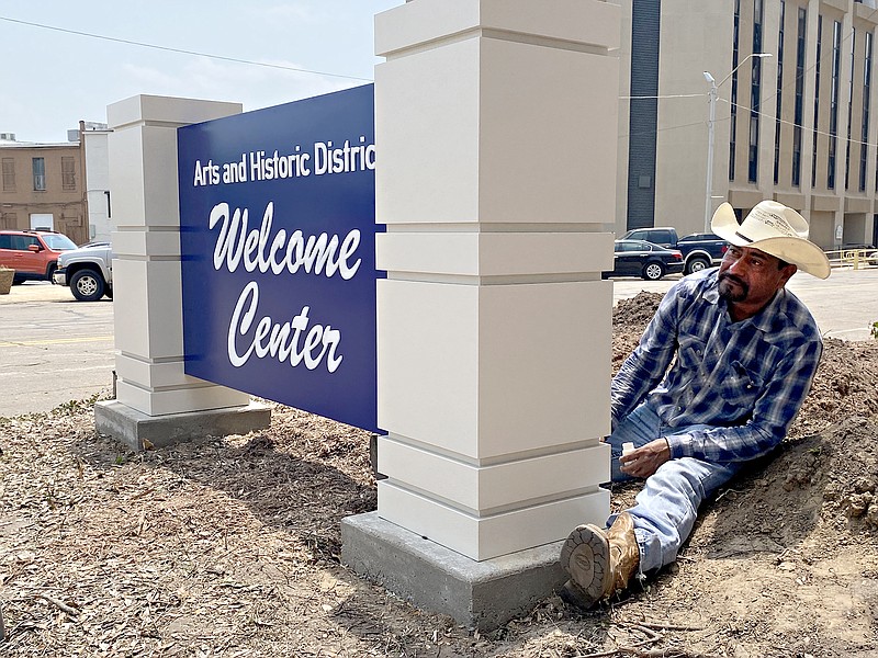 Adolfo De La Torre, of ASI Signage Innovations in Irving, Texas, puts the finishing touches on a new welcome sign Friday, May 20, 2022, at State Line Avenue and Third Street in downtown Texarkana, Texas. De La Torre and co-worker Carlos Carreno said the sign took about a week of work — about three days of construction at ASI and two days of install at the Museum of Regional History. (Staff photo)