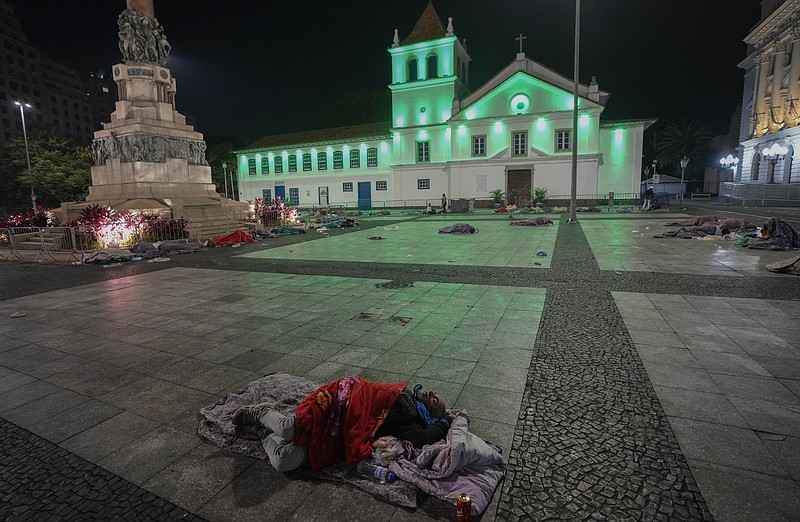 Homeless people sleep at Patio do Colegio Square during a cold night in downtown Sao Paulo, Brazil, early Friday, May 20, 2022. The homeless population in Sao Paulo has increased 30% during the COVID-19 pandemic, a recent census shows. (AP Photo/Andre Penner)