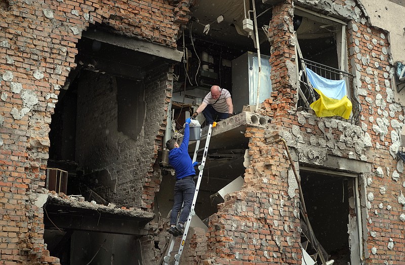 Residents take out their belongings from their house ruined by the Russian shelling in Irpin close to Kyiv, Ukraine, Saturday, May 21, 2022. (AP Photo/Efrem Lukatsky)