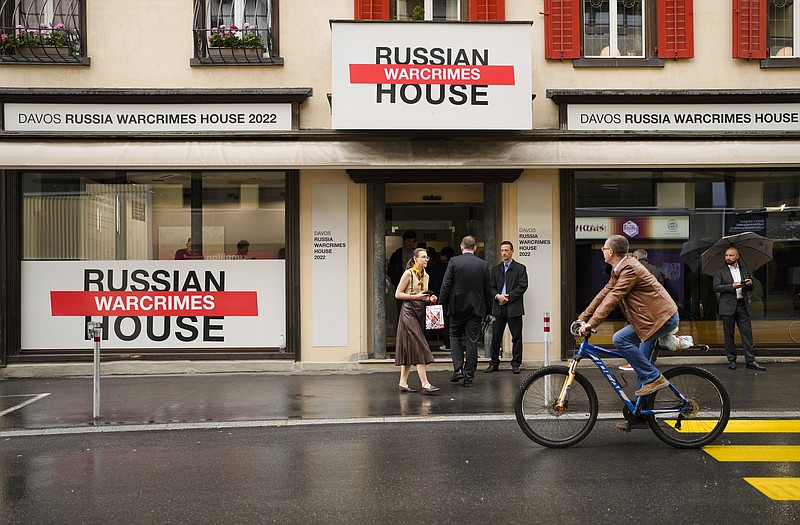 People gather in front of the so-called Russian War Crimes House alongside the World Economy Forum in Davos, Switzerland, Sunday, May 22, 2022. An exhibition with pictures documenting suspected Russian war crimes in the Ukrainian war are to be shown in the house. The annual summit ends Thursday, May 26, 2022. (AP Photo/Markus Schreiber)
