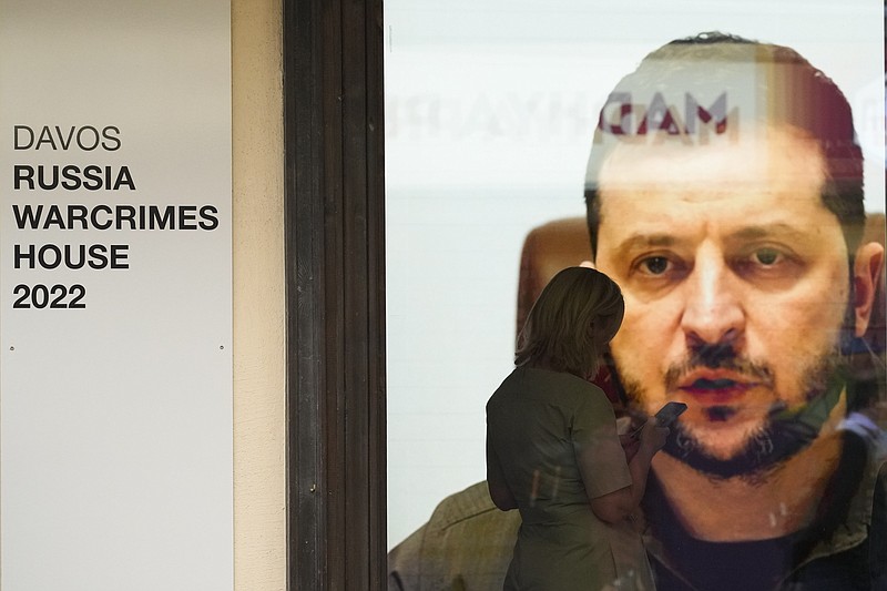 Ukrainian President Volodymyr Zelenskyy speaks on a screen inside a so-called Russian War Crimes House alongside the World Economy Forum in Davos, Switzerland, Sunday, May 22, 2022. An exhibition with pictures documenting suspected Russian war crimes in the Ukrainian war are to be shown in the house. The annual meeting of the World Economy Forum is taking place in Davos from May. 22 until May. 26, 2020.