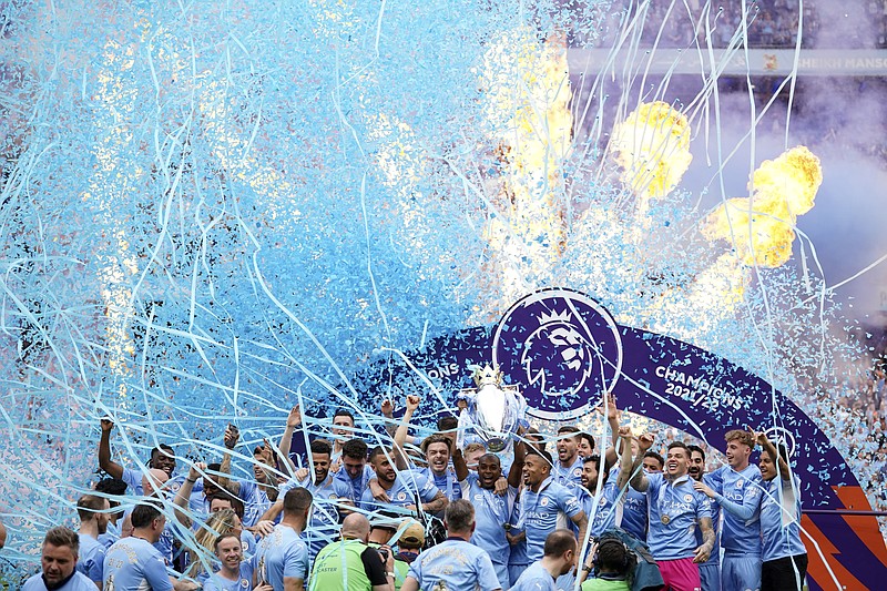 Manchester City players celebrate with trophy after winning the 2022 English Premier League title at the Etihad Stadium in Manchester, England, Sunday, May 22, 2022. (AP Photo/Dave Thompson)