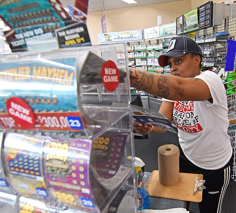 Sekoiyn Phillips, a Corner Store cashier, pulls lottery scratch off tickets for a customer Wednesday, May 12, 2021 at the Corner Store on Stagecoach Road in Little Rock.
 (Arkansas Democrat-Gazette/Staci Vandagriff)