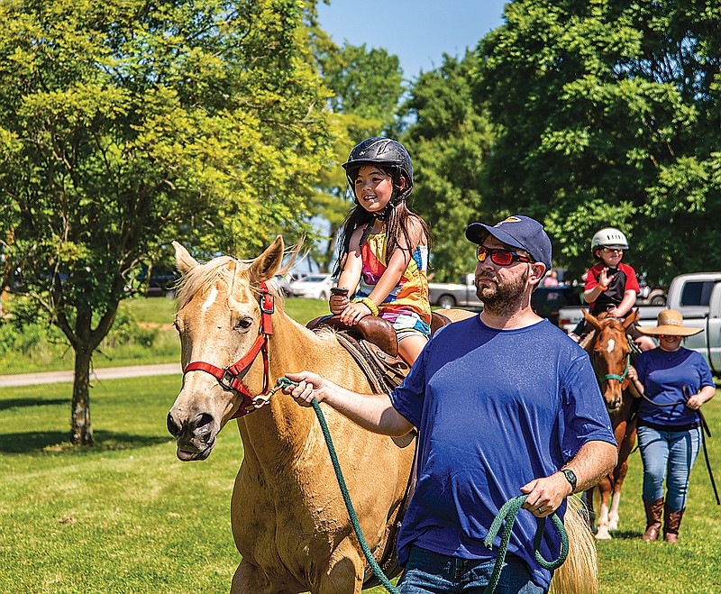 Fay Kipp, 7, enjoys a horse ride at KidsFest Saturday, June 5, 2021, at Ellis-Porter Riverside Park.  A huge crowd turned out to enjoy the great summer weather.  (Ken Barnes/News Tribune)