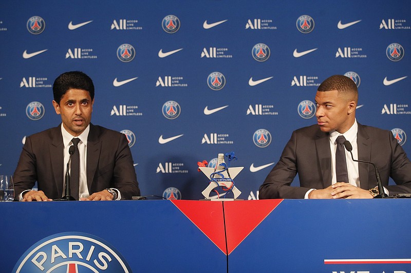 PSG striker Kylian Mbappe, right, and PSG president Nasser Al-Al-Khelaifi attend a press conference Monday at the Paris des Princes stadium in Paris. Mbappé's decision to reject Real Madrid and commit to Paris Saint-Germain for three more seasons marks the start of a large rebuilding project at the French league champion. - Photo by Michel Spingler of The Associated Press