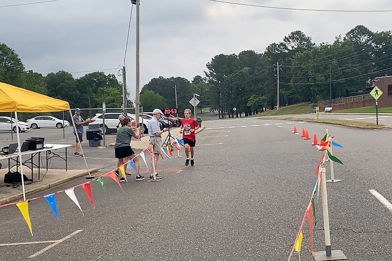 Nathan Harbut crosses the finish line to win the 26th Annual Norma Lampert Memorial Lupus Springers 5K at National Park College Saturday. - Photo by James Leigh of The Sentinel-Record