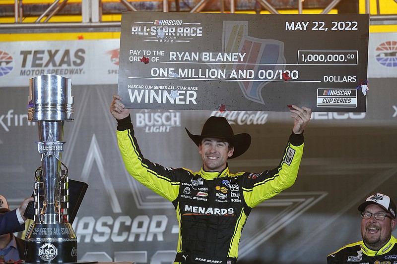 Ryan Blaney (12) hold up the first place check while celebrating in Victory Lane after winning the NASCAR All-Star auto race at Texas Motor Speedway in Fort Worth, Texas, Sunday, May 22, 2022. (AP Photo/LM Otero)