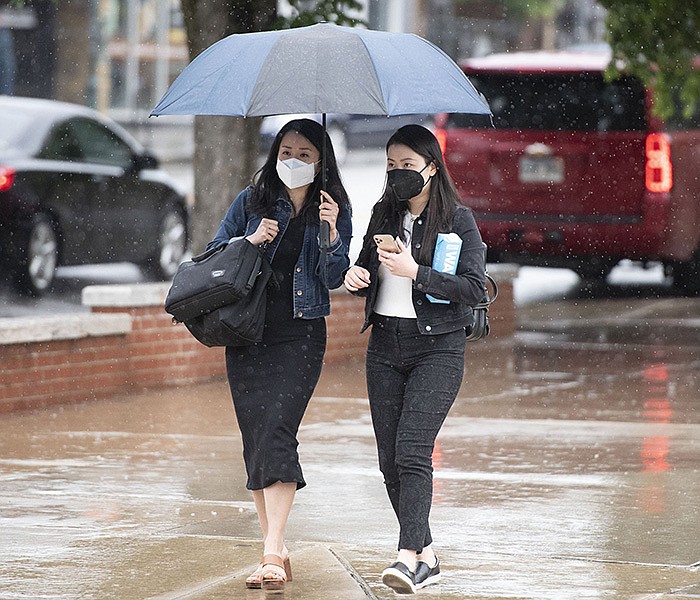 Pedestrians share an umbrella Monday May 23, 2022 as they walk along Dickson St. while rain falls in Fayetteville. The National Weather Service is calling for more rain early this week with high temperatures in the 60s.  See nwaonline.com/220524Daily/ for daily galleries.  (NWA Democrat-Gazette/J.T. Wampler)