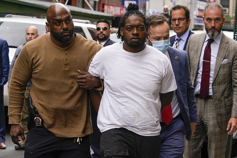 Andrew Abdullah is escorted into the Fifth precinct, Tuesday, May 24, 2022, in New York. Abdullah, the man wanted in an apparently unprovoked fatal shooting aboard a New York City subway train surrendered to police on Tuesday, hours after authorities posted his name and photo on social media and implored the public to help find him. (AP Photo/Mary Altaffer)