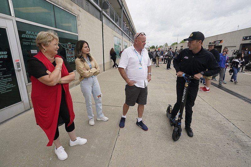 Scott McLaughlin, right, of New Zealand, talks with his parents Wayne and Diane McLaughlin, and his wife Karly McLaughlin, second from left, in Gasoline Alley before qualifications for the Indianapolis 500 auto race at Indianapolis Motor Speedway, Sunday, May 22, 2022, in Indianapolis. (AP Photo/Darron Cummings)