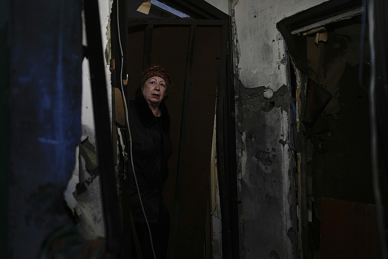 Klavdiya Tyshenko stands at the entrance of her home ruined by shelling in Irpin, outskirts of Kyiv, Ukraine, Tuesday, May 24, 2022. (AP Photo/Natacha Pisarenko)