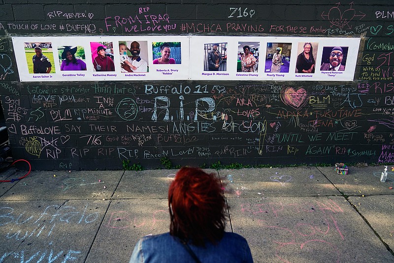 FILE - A person visits a makeshift memorial near the scene of a shooting at a supermarket Thursday, May 26, 2022, in Buffalo, six days before the second anniversary of George Floyd's killing. Floyd's murder, along with a series of killings of other Black Americans wrought a heavy emotional and mental toll on Black communities that have already been burdened and traumatized by centuries of oppressive systems and racist practices. (AP Photo/Matt Rourke, File)