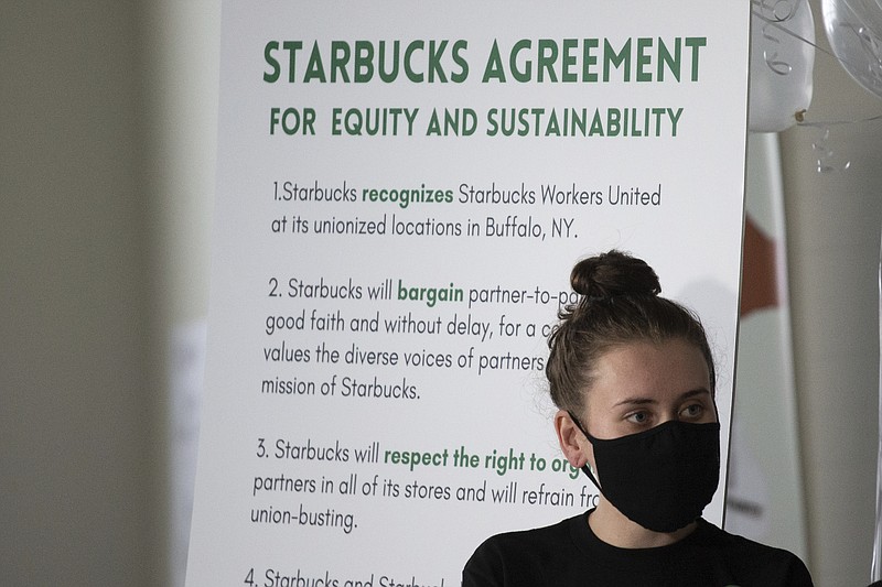 FILE - Alexis Rizzo, a Starbucks employee, stands during a press conference after their union-election viewing party Thursday, Dec. 9, 2021, in Buffalo, N.Y.  It’s become a common sight: jubilant Starbucks workers celebrating after successful votes to unionize at dozens of U.S. stores. But when the celebrations die down, a daunting hurdle remains. To win the changes they seek, like better pay and more reliable schedules, unionized stores must sit down with Starbucks and negotiate a contract. It’s a painstaking process that can take years.   (AP Photo/Joshua Bessex, File)