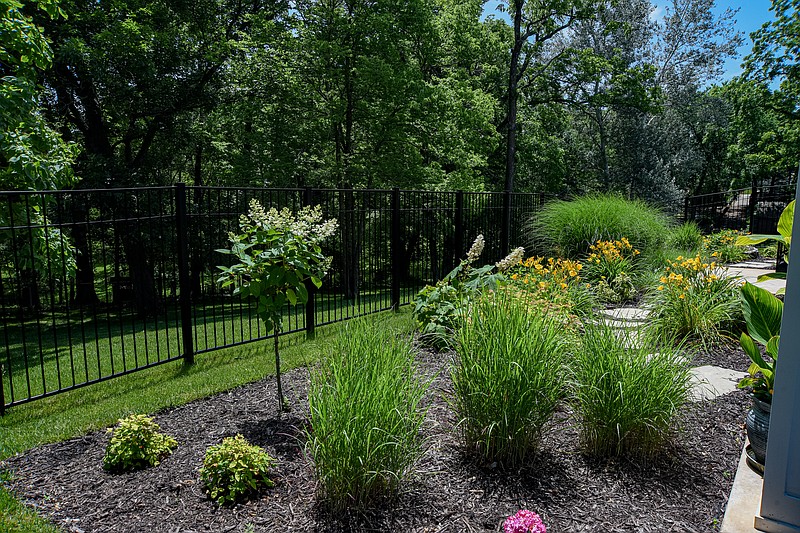 This garden features eye appeal from the start and large stone pavers throughout the flower bed around the back of the house. (Julie Smith/News Tribune photo)