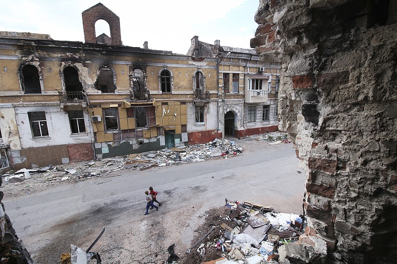 Children walk among buildings destroyed during fighting in Mariupol, in territory under the government of the Donetsk People's Republic, eastern Ukraine, Wednesday, May 25, 2022. (AP Photo)