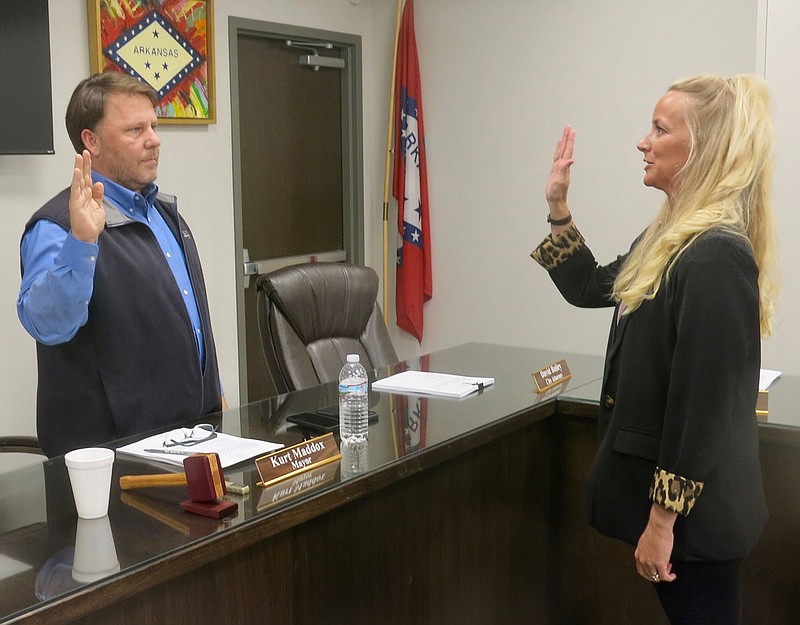 Westside Eagle Observer/SUSAN HOLLAND
Dani Madison (right) raises her hand as Mayor Kurt Maddox swears her in as the new Gravette city clerk/treasurer at the May 26 meeting of the city council. Council members unanimously approved Madison, who has been a member of the planning commission, and she took her seat at the council table.