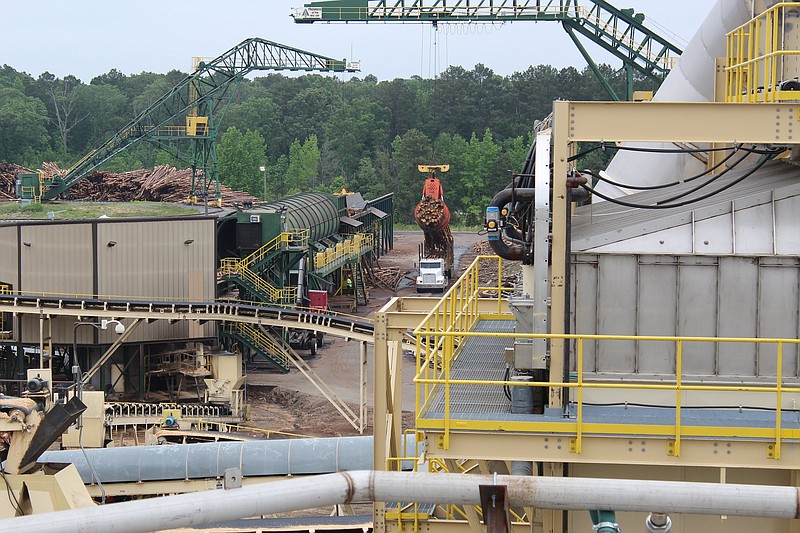 Logs are lifted from a truck at the Highland Pellets factory in Pine Bluff on Tuesday, May 24, 2022.
(Arkansas Democrat-Gazette/Cristina LaRue)