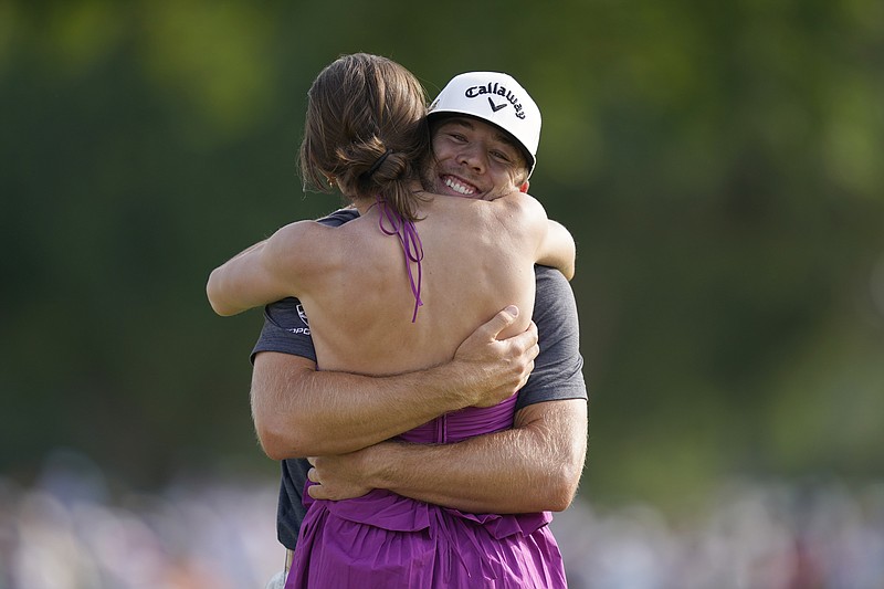 Sam Burns, right, hugs his wife Caroline Burns after winning the Charles Schwab Challenge golf tournament at the Colonial Country Club in Fort Worth, Texas, Sunday, May 29, 2022. (AP Photo/LM Otero)