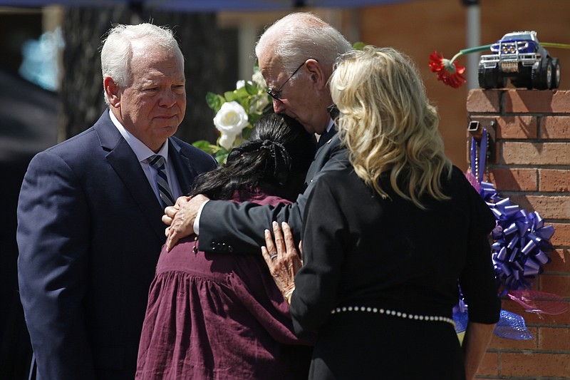 President Joe Biden and first lady Jill Biden comfort Principal Mandy Gutierrez as Superintendent Hal Harrell stands next to them, at a memorial outside Robb Elementary School to honor the victims killed in a school shooting in Uvalde, Texas Sunday, May 29, 2022. (AP Photo/Dario Lopez-Mills)