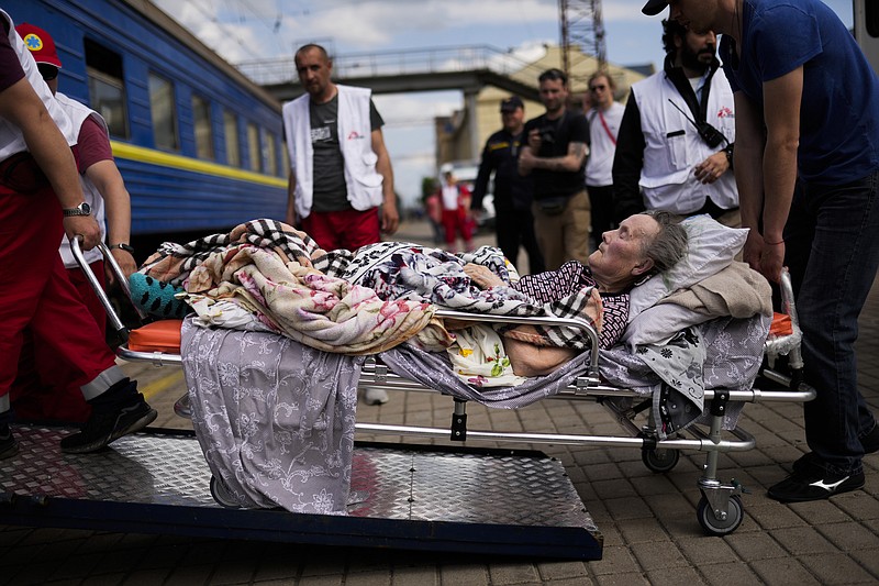 An elderly patient boards a medical evacuation train run by MSF (Doctors Without Borders) at the train station in Pokrovsk, eastern Ukraine, Sunday, May 29, 2022. The train is specially equipped and staffed with medical personnel, and ferries patients from overwhelmed hospitals near the front line, to medical facilities in western Ukraine, far from the fighting. (AP Photo/Francisco Seco)