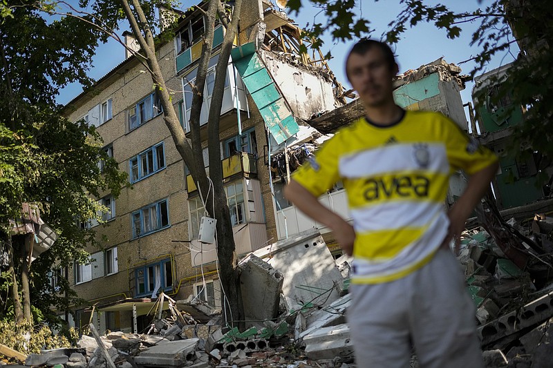 A local resident stands next to a residential building heavily damaged in a Russian bombing in Bakhmut, eastern Ukraine, Monday, May 30, 2022. (AP Photo/Francisco Seco)
