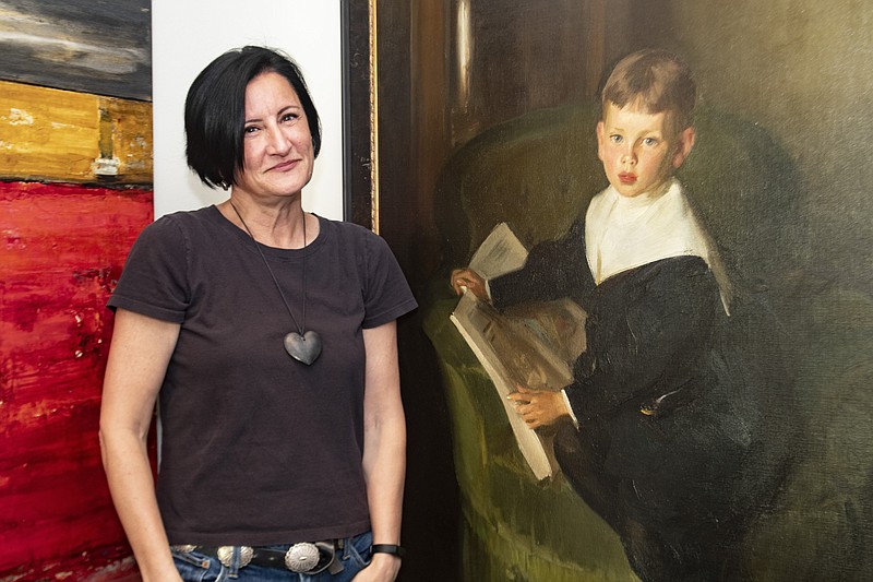 Jennifer O’Brien stands next to the painting of William O’Brien Jr. after conservation and cleaning by Norton Arts. (Arkansas Democrat-Gazette/Cary Jenkins)