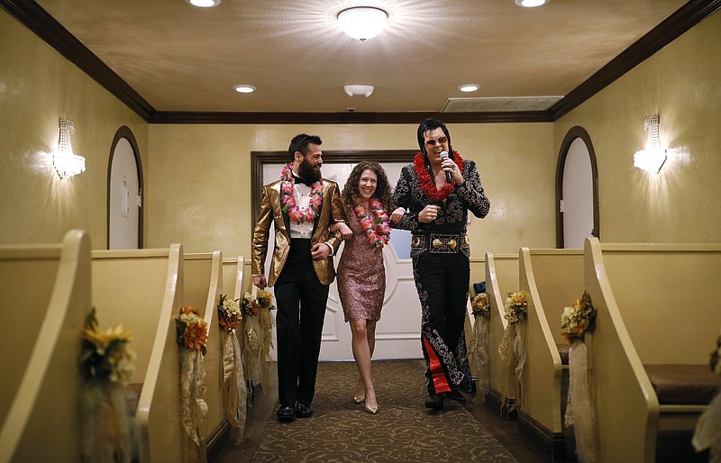Elvis impersonator Brendan Paul (right) walks down the aisle during a wedding ceremony for Katie Salvatore (center) and Eric Wheeler at the Graceland Wedding Chapel in Las Vegas. Authentic Brands Group (ABG) sent cease-and-desist letters earlier in May to multiple chapels, saying they had to comply by the end of May, the Las Vegas Review-Journal reported. (AP file photo/John Locher)
