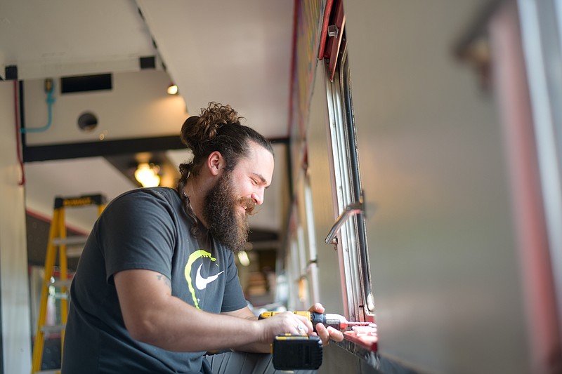 Michael Perry works on renovating the Flying Crow train car into his coffee shop, Alley Cats. (Photo by Erin DeBlanc)