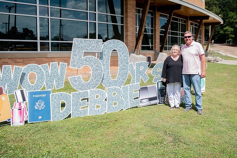 Debbie Stinson, secretary/office manager in El Dorado Department of Public Works, poses with Public Works Director Robert Edmonds next to signs commemorating Stinson's 50th anniversary as a city employee. A surprise party/reception was held June 1 in honor of Stinson's five decades of service to the city. (Courtesy of Elizabeth Haynes/Special to the News-Times)