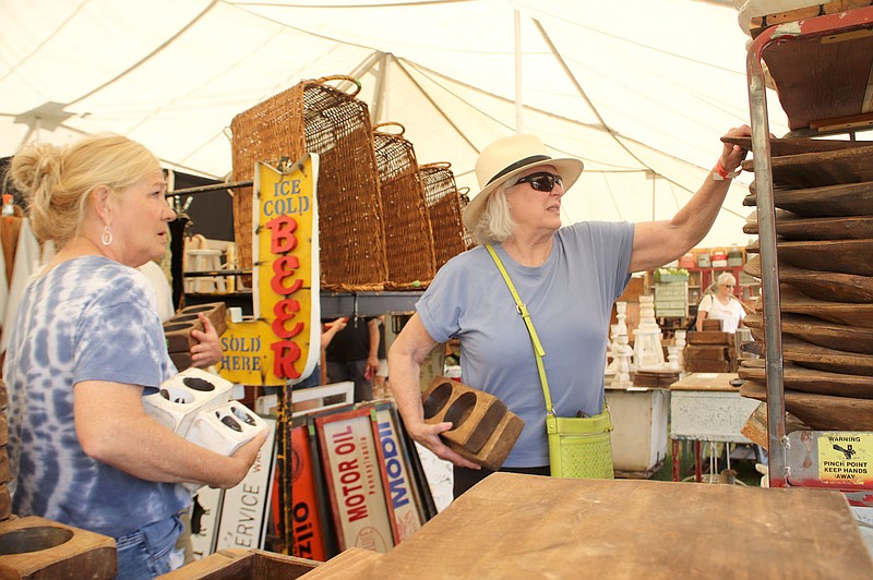 PHOTOS  BY LYNN KUTTER ENTERPRISE-LEADER
Rhoada Dossett, left, and Marsha Scott, both of Fayetteville, select wood containers to use for plants at The Junk Ranch on Friday. They were shopping at Chicken Creek Concepts, a vendor booth from Monkey Island, Okla., which is on Grand Lake. This is the fifth year the vendor has been at The Junk Ranch vintage fair in Prairie Grove.