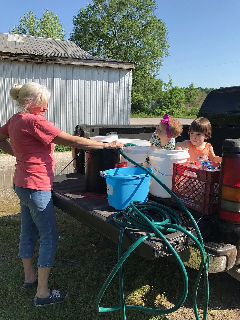 PHOTO PROVIDED BY DALE MITCHELL. Dale Mitchell bathing her grandchildren Jonah and Pearl in buckets. Mitchell has been driving buckets to the pumper tanker as they're too heavy to constantly refill.