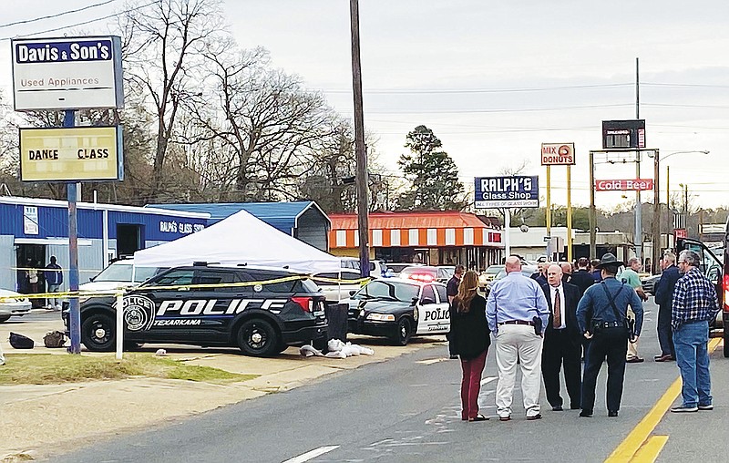 Law enforcement officers converse near the scene where one Bowie County fugitive was killed and another apprehended during an officer-involved shooting Monday, March 21, 2022, in the 200 block of East Street in Texarkana, Arkansas. Two correctional officers were fired in April, following the inmates' escape from the Bowie County jail, for documenting face-to-face checks that did not actually occur, according to Sheriff Jeff Neal. (Staff file photo)