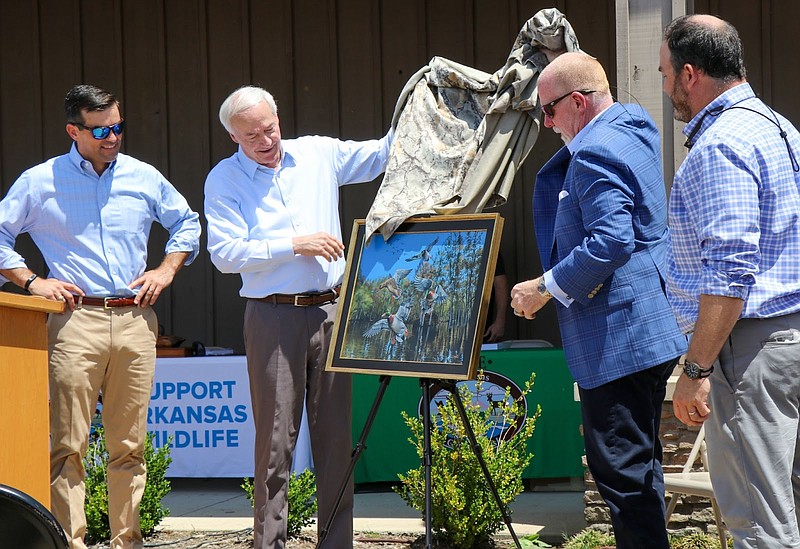 Austin Booth (left) Arkansas Game and Fish Commission director, Gov. Asa Hutchinson, artist Clay Connor, and Deke Whitbeck, Arkansas Game and Fish Foundation president, unveiled the 2022-23 Arkansas Duck Stamp artwork at Rich-N-Tone Taproom at Stuttgart for Callapalooza 2022 on Saturday. (Special to The Commercial/Arkansas Game and Fish Commission)