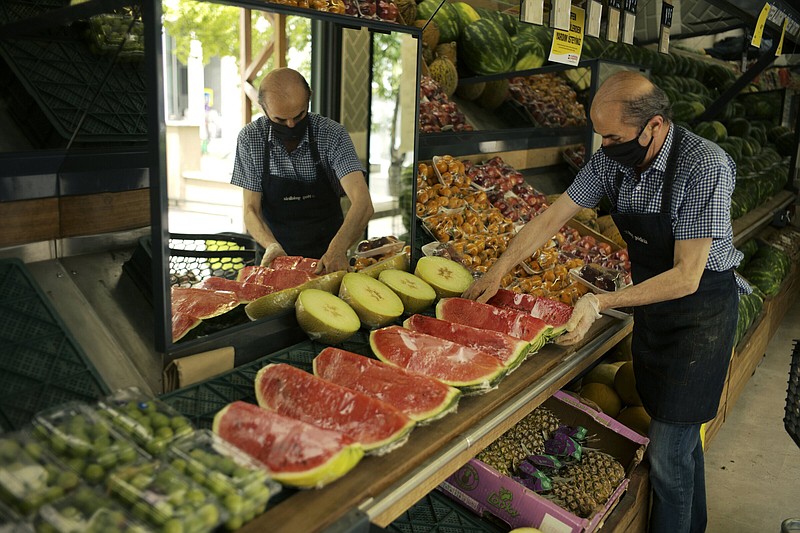 A worker arranges fruit for sale a food market in Ankara, Turkey, Friday, June 3, 2022. Annual inflation in Turkey hit 73.5% in May, according to official data released by the Turkish Statistical Institute on Friday, as a cost-of-living crisis in the country deepens. (AP Photo/Burhan Ozbilici)