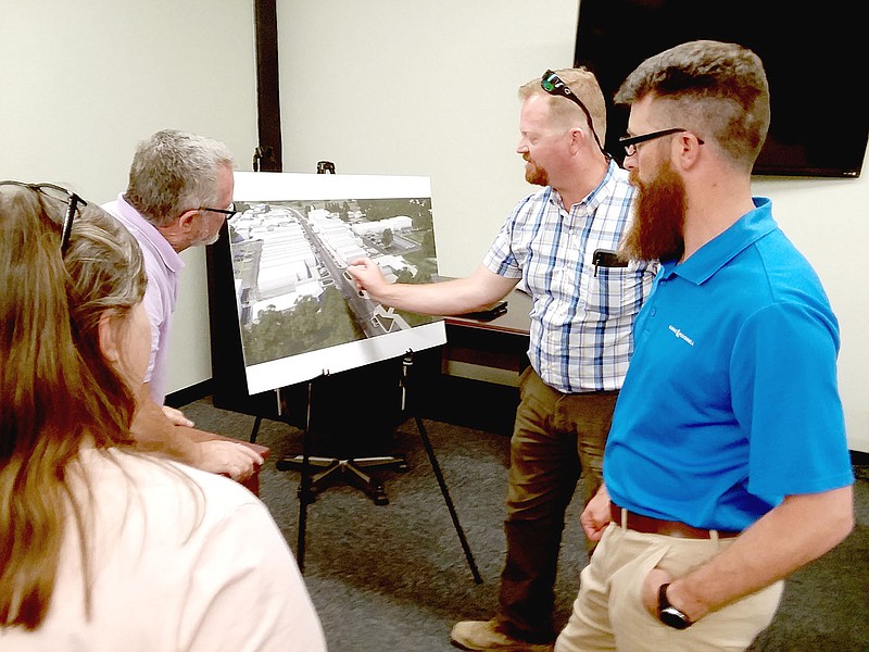 MARK HUMPHREY  ENTERPRISE-LEADER/Burns and McDonnell civil engineer William Pattengill (checkered shirt) and project manager Steven Beam (far right) answer a question from Kay Shreve (left), owner of "The Locals Flea Market," while city administrative assistant Larry Olerich looks on during an information meeting regarding planned renovations to Prairie Grove infrastructure including waterlines, streets, sidewalks, drainage and landscaping in the historic downtown area. The city hosted the meeting attended by several downtown merchants, local business owners and residents in the district courtroom on Tuesday, June 7, 2022.