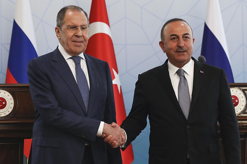 Russian Foreign Minister Sergey Lavrov, left, and Turkish Foreign Minister Mevlut Cavusoglu shake hands at the end of a joint news conference in Ankara, Wednesday, June 8, 2022. (AP Photo/Burhan Ozbilici)