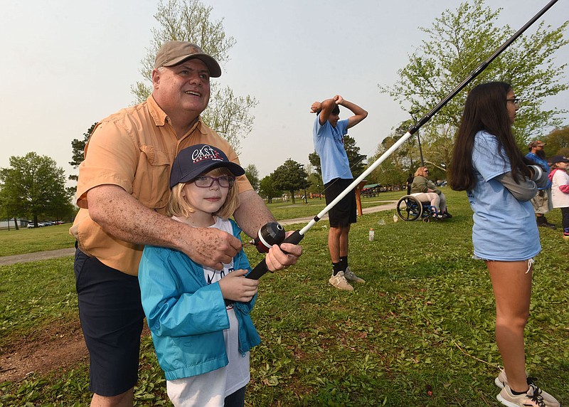 Joey Breaux of Fayetteville helps Tabitha Short, 8. with her fishing during a Cast For Kids event held April 30 2022 at Murphy Park in Springdale. The national Cast For Kids program helps special-needs youngsters get outdoors and enjoy a morning of fishing.
(NWA Democrat-Gazette/Flip Putthoff)
