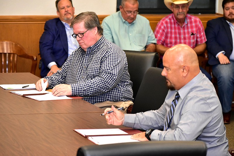 Chicot County Judge Mack Ball, seated left, and Mark Boswell of MD Power sign a lease agreement for MD Power to relocate to the former location of the Chicot County landfill at the county courthouse Friday, June 10, 2022. (Pine Bluff Commercial/I.C. Murrell)