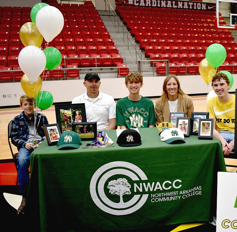 MARK HUMPHREY ENTERPRISE-LEADER/Farmington 2022 graduate Micah Grusing signed a national letter of intent to compete in distance running for Northwest Arkansas Community College, of Bentonville, near the end of his senior year on April 13, 2022, at Cardinal Arena. Micah’s family accompanied him at the signing ceremony (from left): brother Asher Grusing, 10, a rising fifth grader, father Brent Grusing, Micah Grusing, mother Mindy Grusing, and brother Caleb Grusing, 19. Micah excelled in both cross country in the fall as well as track and field in the spring at Farmington.