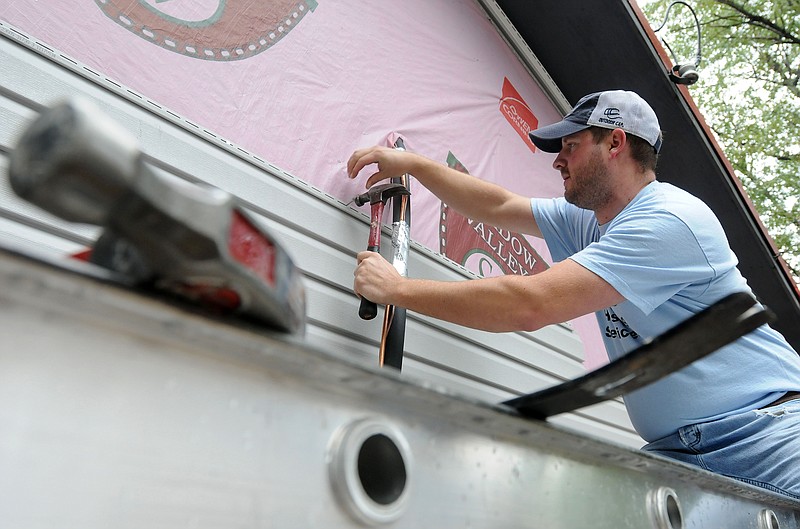 Jonathon Lindeman nails siding to the house at 1606 South Westend St. in Springdale during its renovation, a project sponsored by the City of Springdale's Community Development Block Grant. (NWA Democrat-Gazette File Photo/Samantha Baker)