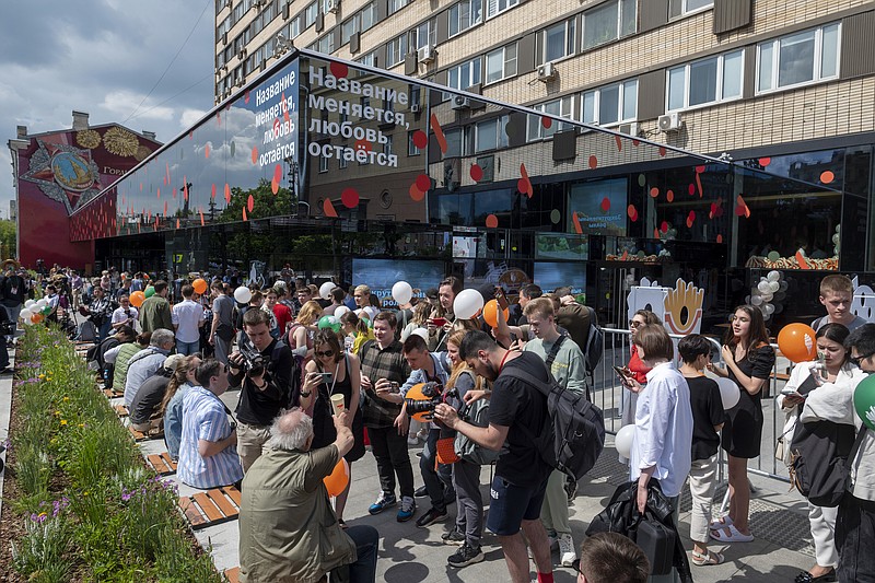People lineup to visit a newly opened fast food restaurant in a former McDonald's outlet in Bolshaya Bronnaya Street in Moscow, Russia, Sunday, June 12, 2022. The sign reads 'The Name Changes, Love Remains'. The first of former McDonald's restaurants is reopened with new branding in Moscow. The corporation sold its branches in Russia to one of its local licensees after Russia sent tens of thousands of troops into Ukraine. (AP Photo/Dmitry Serebryakov)