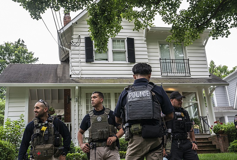 Law enforcement officers stand guard as protesters march past Supreme Court Justice Brett Kavanaugh's home on June 8, 2022, in Chevy Chase, Maryland. An armed man was arrested near Kavanaugh's home Wednesday morning as the court prepares to announce decisions for about 30 cases. (Nathan Howard/Getty Images/TNS)